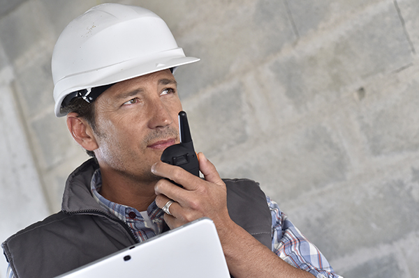 Entrepreneur on building site using walkie talkie